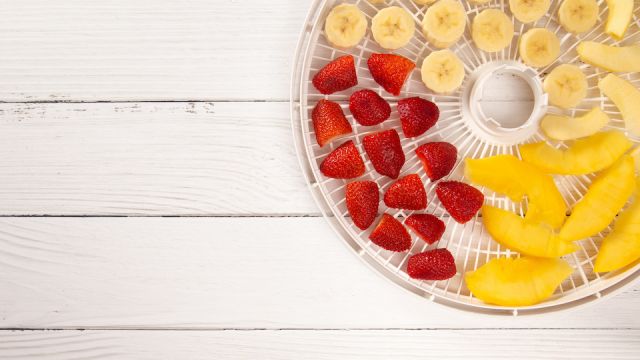 A Tray of Fruit Being Prepared to Dehydrate on a Wooden Table